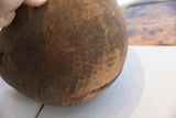 Aged dark wood surface of antique African bowl with incised patterns and natural cracks.