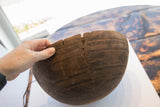 Incised geometric patterns and old repairs on the dark wood of the antique African bowl.