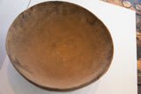 Close-up of the antique hand-carved wooden bowl's aged interior, showing natural patina and texture.