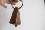 Hand holds the vintage African Yoruba iron bell, revealing its aged, textured iron.
