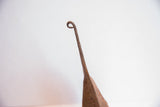 Curved, rustic iron handle of the handmade African Yoruba bell.