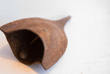 Close-up view of the African Yoruba iron bell's rustic clapper and time-softened texture.
