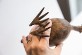 Close-up of the stylized pronged feet and aged texture on the vintage bird casting.