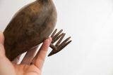 A close view of the aged, textured prongs on the handmade African bird casting.