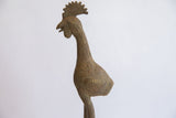 Close-up of the African bird casting's head, showing its detailed comb and etched texture.