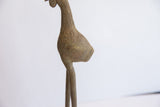 Aged patina and etched feather details on the body of a vintage African bird casting.