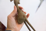Hand holding the vintage African bird casting to show its rustic handmade texture.
