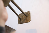Underside view of the vintage bird casting's textured square metal base.