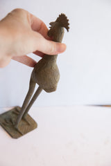 Close view of the vintage bird casting's head, comb, and textured body.