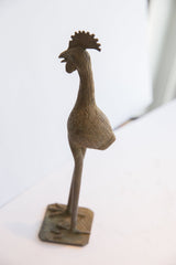 Angled view of a vintage African bird casting with its etched body and prominent comb.