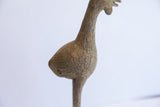 The textured surface and incised feather details on a vintage bird casting.