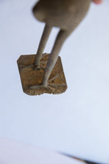 Overhead view of the vintage bird casting's feet and textured metal base.