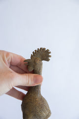 Detail of the textured, fan-like comb and head on the vintage African bird casting.