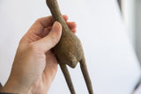 Textured body of a vintage African bird casting with hand-etched details.