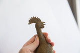 Detailed profile of the vintage African bird casting's head, showing its aged patina and crest.