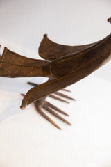 Detail view of the vintage African bird casting's curved beak and textured, rustic surface.