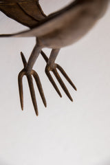 Underside view of the vintage African bird's textured, fork-like metal feet.