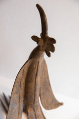 Upward view of the bird casting's head, focusing on the textured patina and elegant curved beak.
