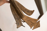 Hand-etched patterns on the layered wings and fanned tail of an African bird casting.