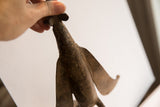 Upward view of the aged patina and hand-worked texture on the vintage bird casting.