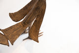 Incised geometric patterns and aged patina on the tail of the vintage African bird figure.