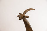 Textured detail of the vintage bird casting's sculpted crest and long curved beak.