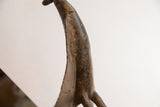 Close-up view of the bird casting's neck showing its textured, aged patina.