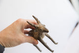 A vintage African antelope sculpture held in hand, showing its scale and aged patina.