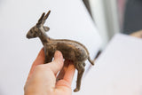 Side profile of a handmade African antelope sculpture held to show scale and finish.