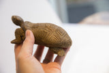 Vintage African tortoise sculpture held in hand, showing its scale and carved texture.