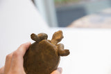 Underside view showing the handmade texture and base of the tortoise sculpture.