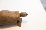Close-up of the vintage tortoise sculpture's aged patina and hand-carved details.