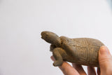 Side profile of a vintage African tortoise sculpture showing hand-carved details.