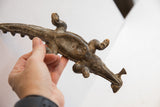 Angled overhead view of the vintage alligator sculpture highlighting the fish on its back and rustic texture.