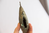 Textured vintage African fish casting with green patina and distinctive side opening.
