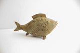 Side profile of a vintage African fish casting with etched scales and a green patina.