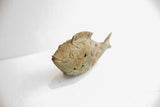 Angled view of the vintage African fish casting highlighting its handmade charm and textured body.