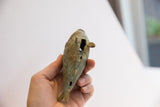 Angled top view of the vintage African fish casting showing its patinated texture.