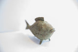 African fish casting face with weathered green patina, spiral, and ribbed textures.