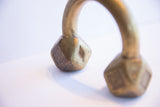 Close-up of the geometric base on an antique African cuff showing aged patina and markings.