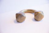 Aged patina on the hand-crafted, geometric ends of an antique African cuff.