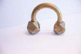 Symmetrical front view of a handcrafted antique African cuff bracelet with geometric ends.