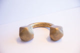 The symmetrical shape and solid geometric ends of an antique African cuff bracelet.