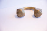 Hand-etched geometric patterns on the cube-shaped terminals of an antique African cuff.