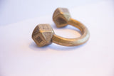 Etched geometric patterns on the faceted terminals of an antique African bracelet.