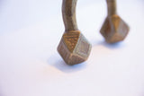 Hand-etched geometric triangle motifs on the faceted brass terminals of the cuff bracelet.