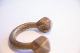 Carved geometric terminal of an antique African cuff showing its aged patina and surface wear.