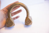 Antique African cuff bracelet held in a hand to demonstrate its scale and form.