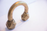 Angled view showing the faceted geometric terminals of the antique African cuff.