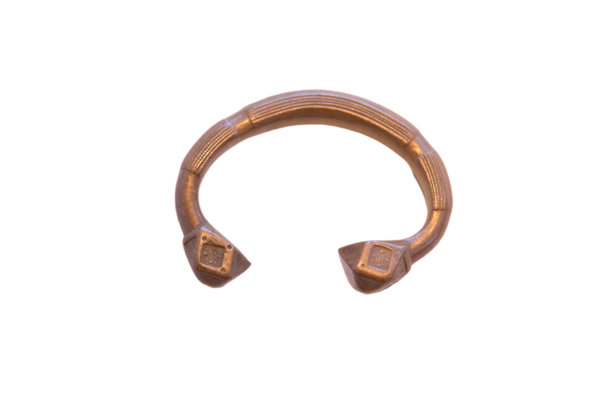 Antique African copper cuff bracelet with etched geometric details and flared square ends.